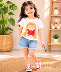 Girl wearing doll print t-shirt and denim shorts