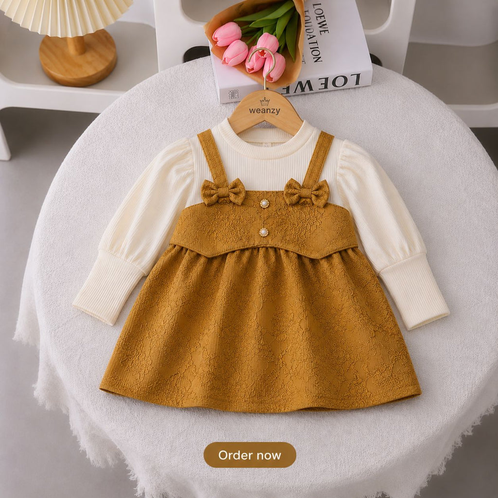 Girl wearing mustard bow suspender dress set with full sleeve top